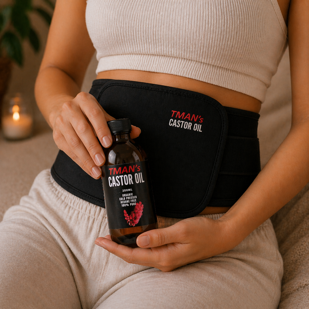 Person holding a bottle of TMAN'S CASTOR OIL with a branded wrap.