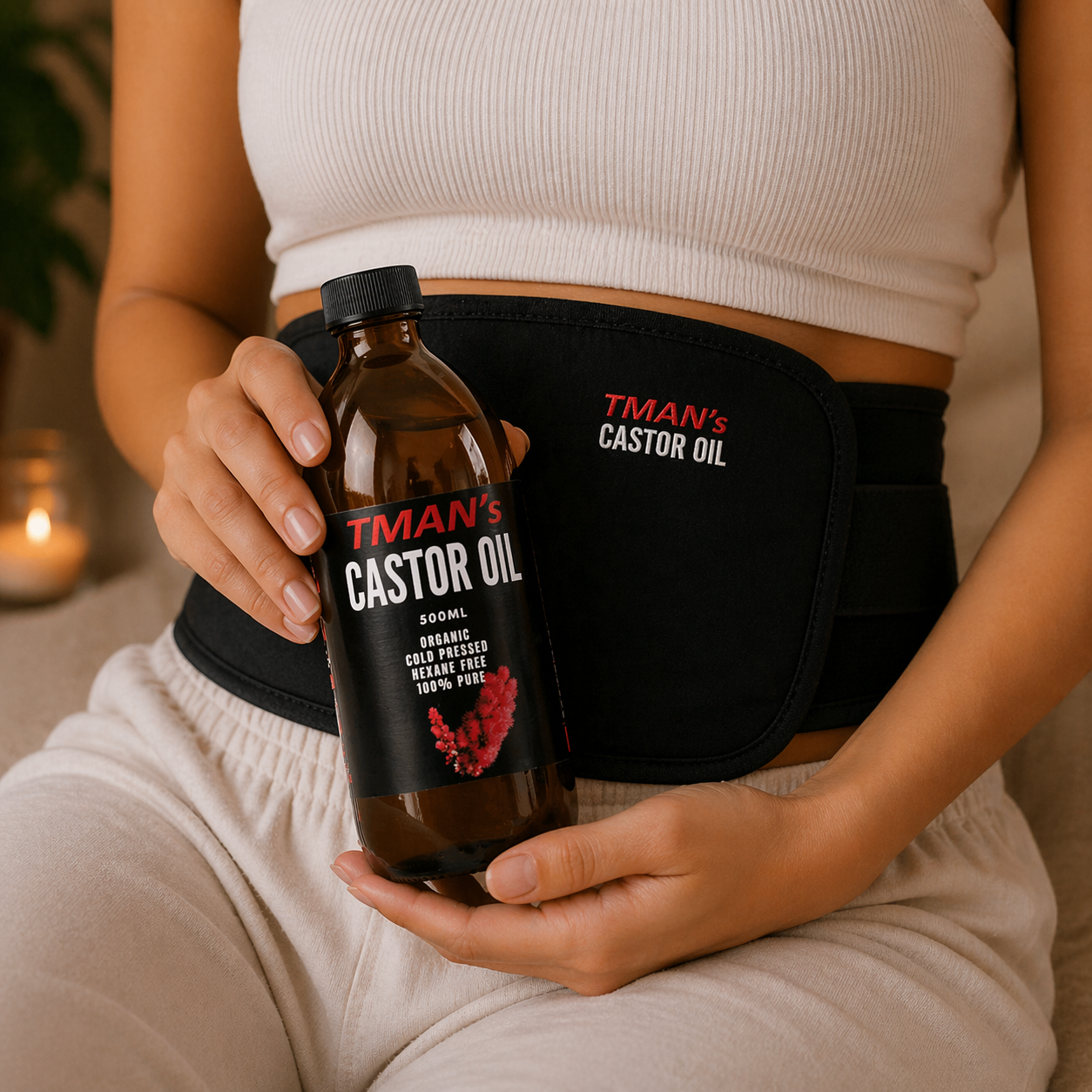 Person holding a bottle of TMan's Castor Oil with a black wrap featuring the brand name.